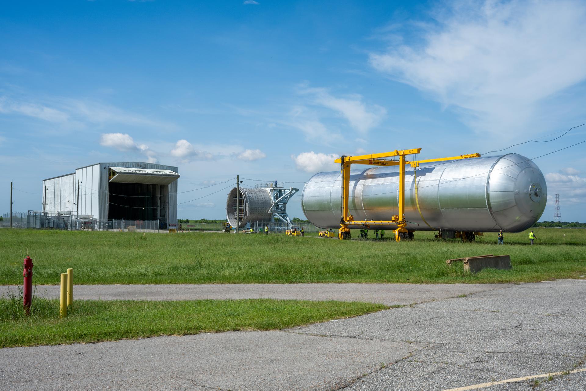 Crews at NASA’s Michoud Assembly Facility in New Orleans transport the 130-foot-tall liquid hydrogen tank from the proof testing building to the main factory on July 15. The liquid hydrogen tank will form part of the core stage for the SLS (Space Launch System) rocket for the agency’s Artemis IV mission, providing thousands of gallons of super-cold propellant to the rocket engines during launch. Soon, teams with SLS prime contractor, Boeing, will move the tank into the facility’s vertical assembly building for cleaning operations.   The liquid hydrogen propellant tank is one of five major elements that make up the 212-foot-tall SLS rocket stage. The core stage, along with its four RS-25 engines at its base, produce more than two million pounds of thrust to help launch NASA’s Orion spacecraft, astronauts, and supplies beyond Earth’s orbit and to the lunar surface for Artemis.      